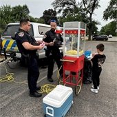 Police Officers Serving Popcorn to Resident